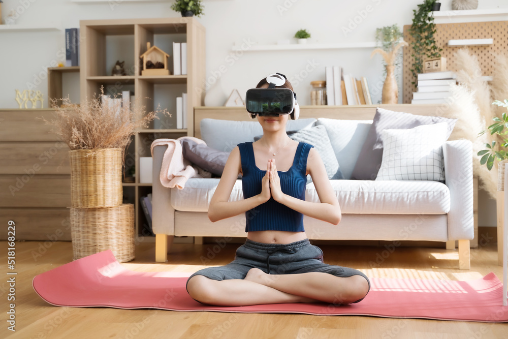 年轻亚洲女性在家戴VR眼镜做瑜伽