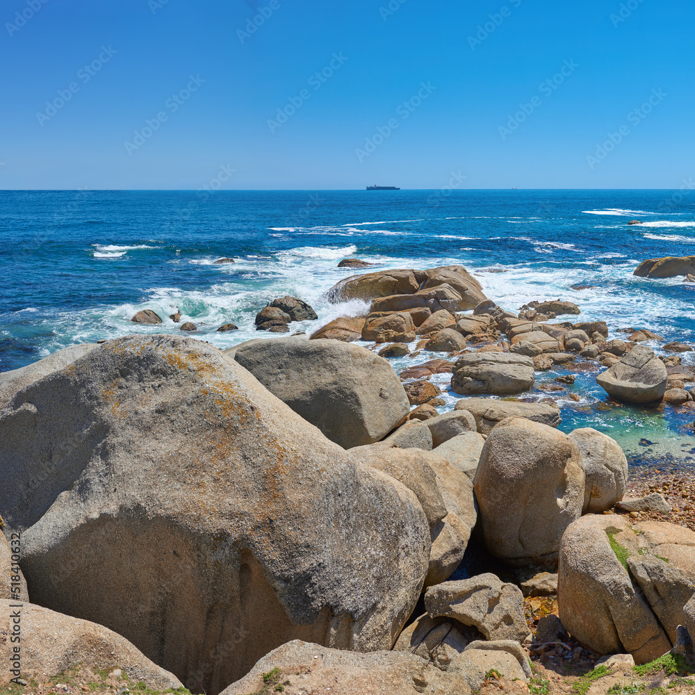 美丽的海景海滩波浪拍打着海水中的巨石或大石头。一个夏天