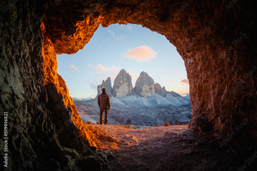 Tre Cime Di Lavaredo在令人难以置信的橙色日落光线下达到顶峰。从山上的洞穴俯瞰