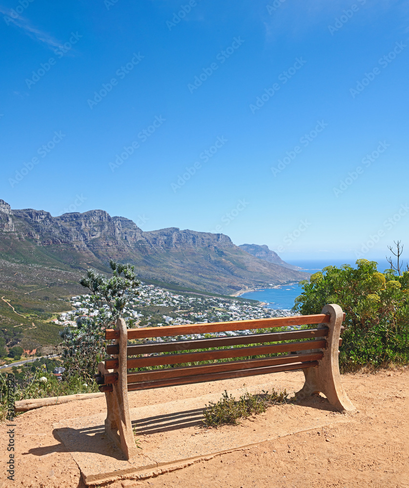 山上悬崖附近的长椅，在蓝天复制空间上可以欣赏到城市大海的壮丽景色。La