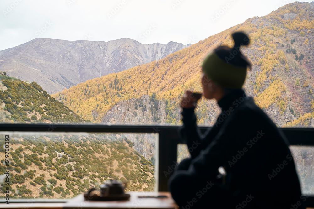 亚洲女人喝茶时从阳台上看风景