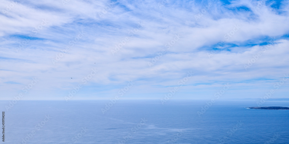 美丽、平静、宁静的海洋和蓝天下的云朵，还有一个热带小岛和