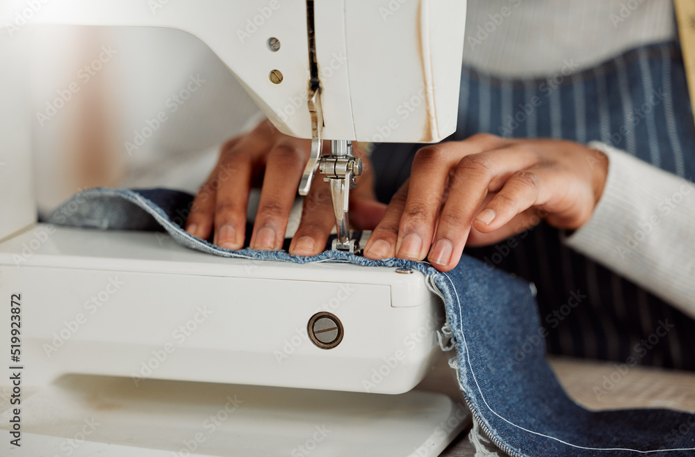 一位专业女设计师坐在工作室缝纫机上的特写手。过程