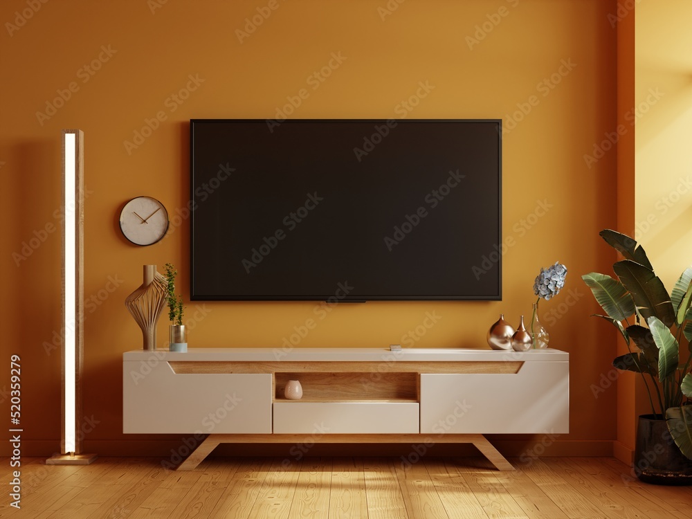 黄色墙壁背景的电视室，现代客厅装饰，配有电视木橱柜。