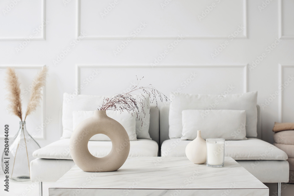 现代斯堪的纳维亚风格的室内景观，配有沙发和时尚花瓶，家庭舞台和极简主义组合