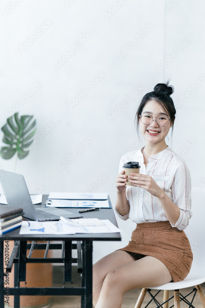 亚洲女性在办公室里用笔记本电脑工作。商业金融概念。