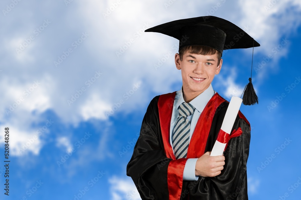 研究生男学生身穿典礼服，头戴毕业帽，手持证书。男子庆祝