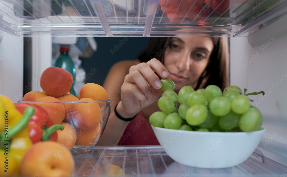 女人在冰箱里拿水果