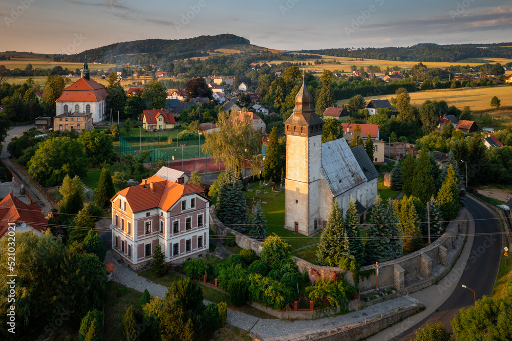 历史悠久的Siedlecin镇上的教堂被波伯山谷景观中的落日照亮