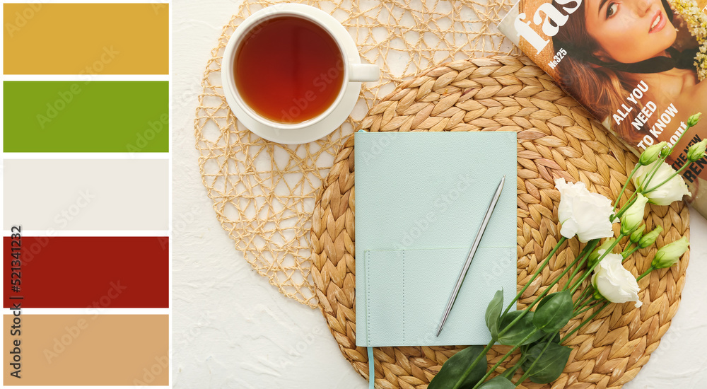 白色背景上有钢笔、一杯茶、杂志和鲜花的笔记本。不同的颜色图案