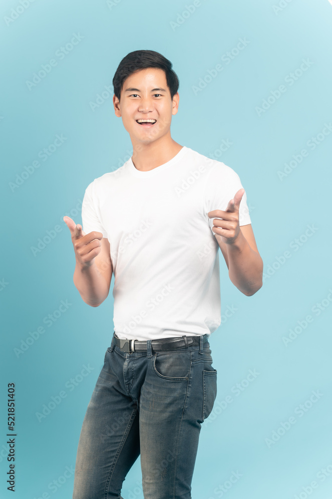 穿着白色t恤和牛仔裤的漂亮亚洲人，蓝色背景隔离