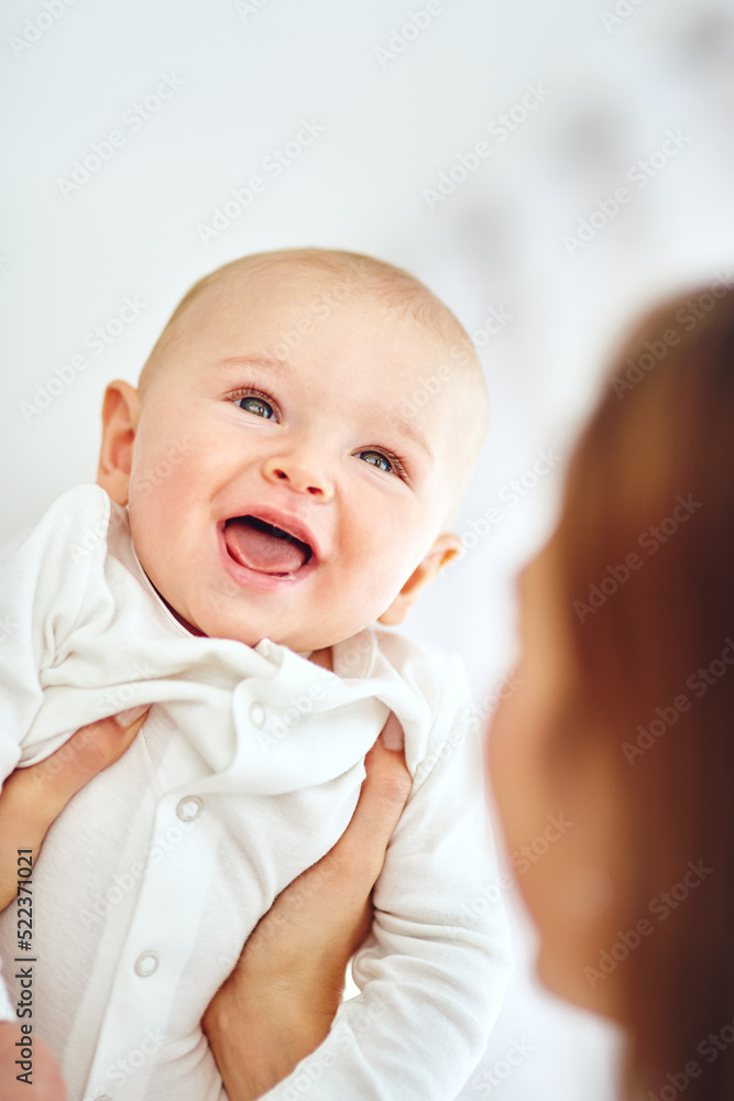 Cute, little and happy baby in the arms of his mother or single parent. Innocent, pure and adorable 