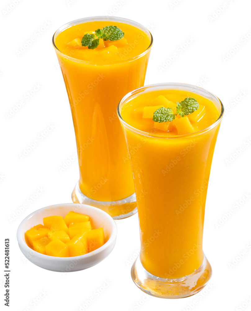 新鲜美味的芒果汁奶昔，装在白底隔离的玻璃杯中。
