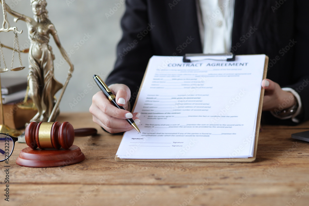 Female lawyer in a law firm holding contract documents explaining the terms of the legal agreement a