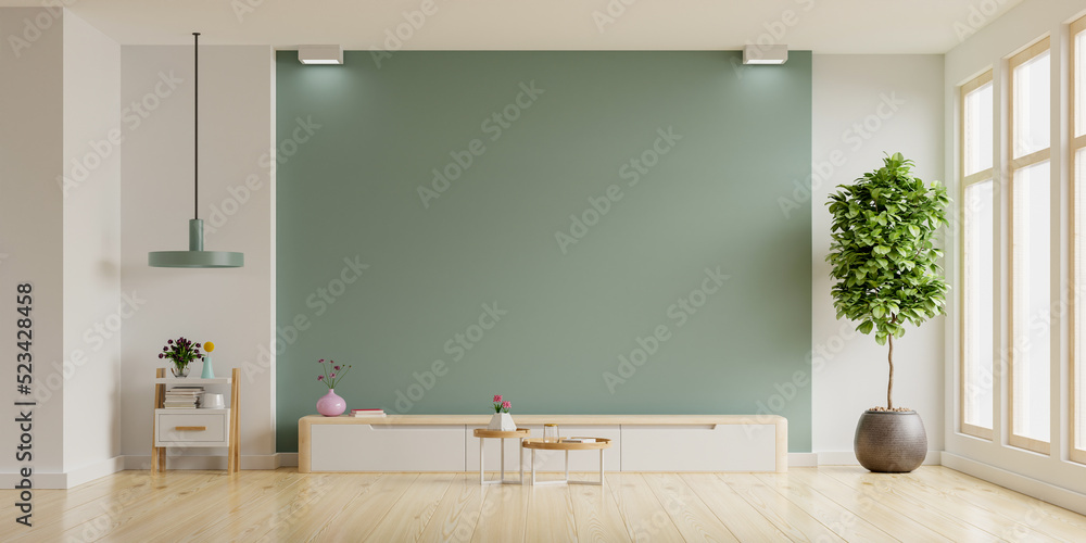 Modern interior of living room with cabinet for tv on green color wall.