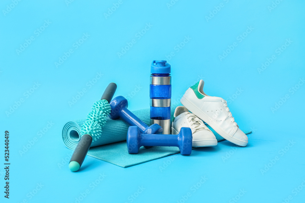 一套彩色背景的运动器材、鞋子和一瓶水