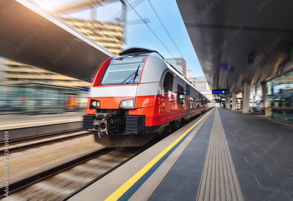 维也纳日落时分，高速列车在火车站上行驶。红色现代城际乘客