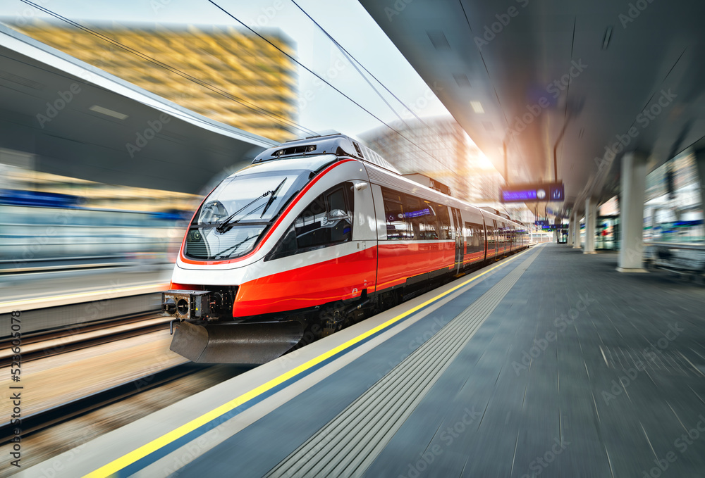 维也纳日落时分，高速列车在火车站上行驶。红色现代城际乘客