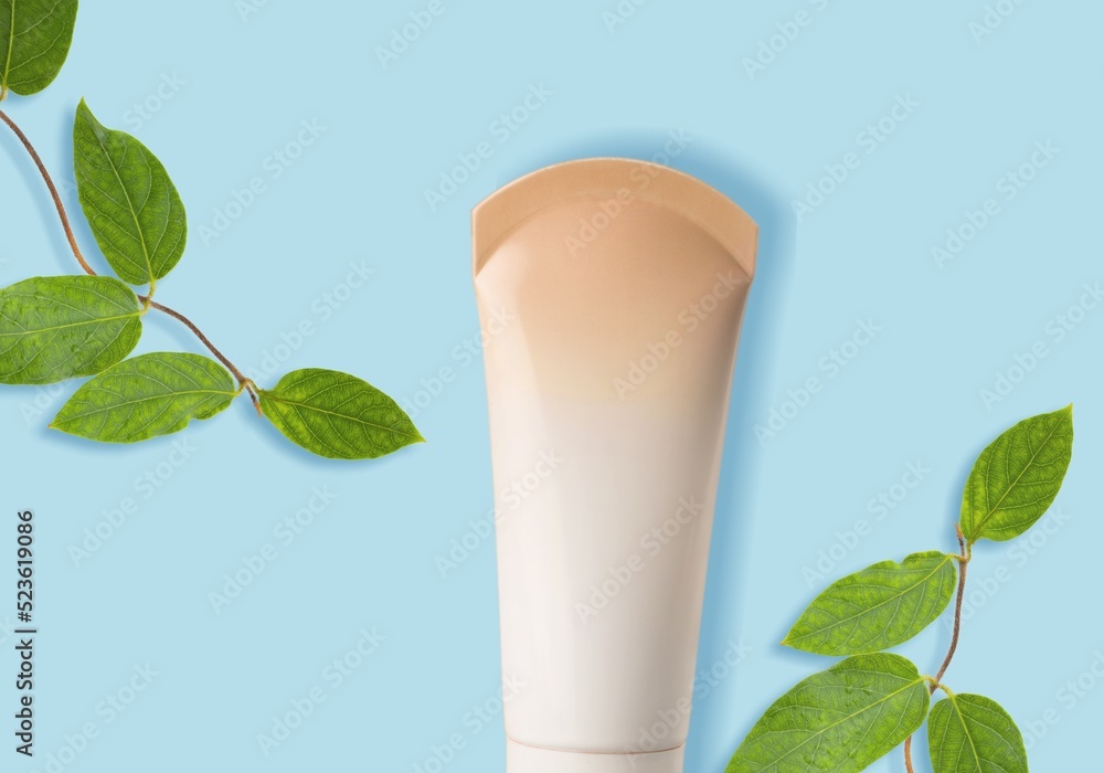 White Cream tube and branches with young small leaves. Cosmetic skincare product blank plastic packa