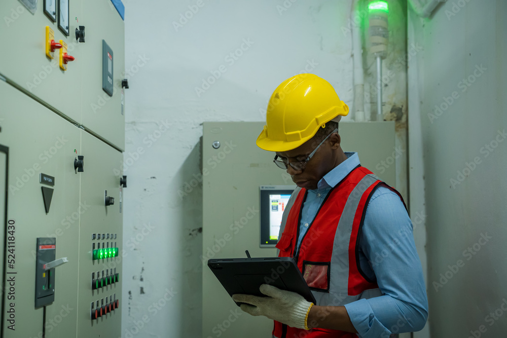 工程师检查控制室或服务器室的电气系统和面板。
