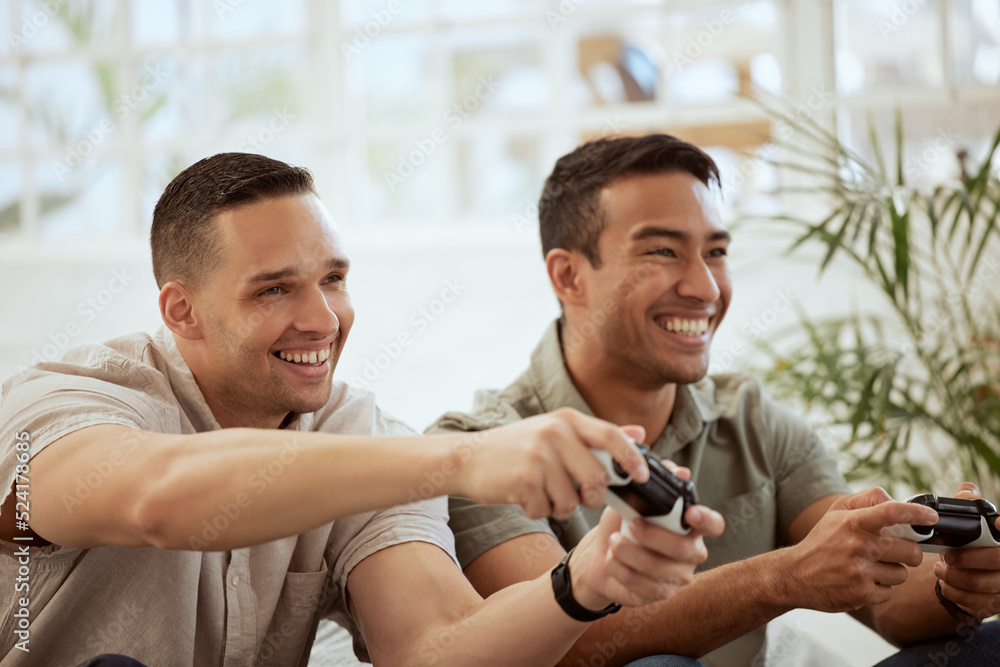 微笑的男性朋友玩电子游戏机，玩得很开心，在家一起玩。年轻