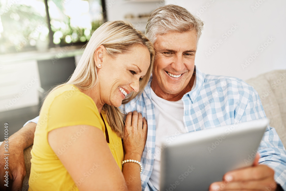 快乐、放松、相爱的成熟情侣在放松的同时一起在平板电脑上看电影