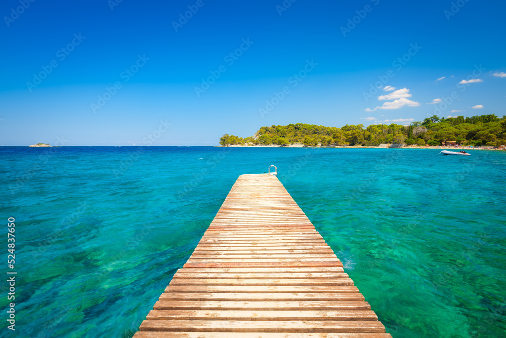 夏季海上码头。碧蓝的大海和岩石环绕的海岸。清澈的海水和晴朗的天空。亚得里亚海