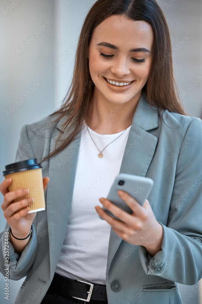 社交媒体上快乐的商务女性，带着电话，在办公室里喝着咖啡微笑。公司