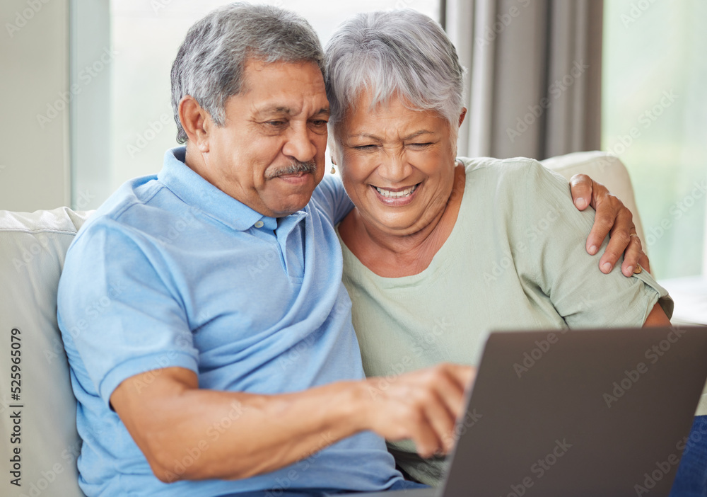 老年夫妇在客厅沙发上的笔记本电脑上进行视频通话、社交媒体或互联网。R