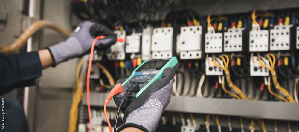 电力和电气维护服务，工程师手持交流万用表检查电气