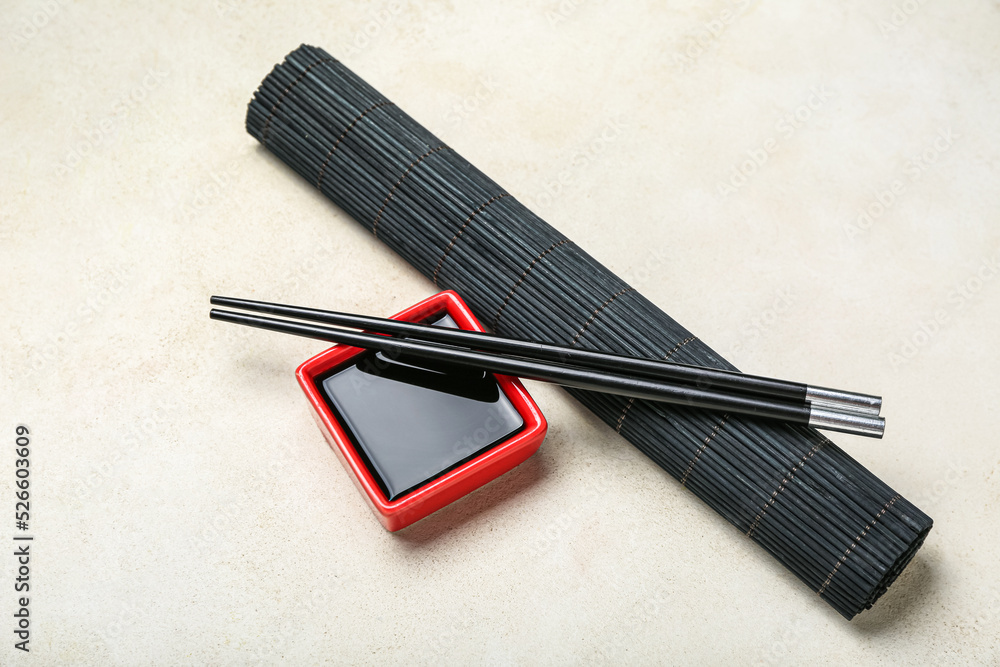 白底红碗酱油、筷子和竹席