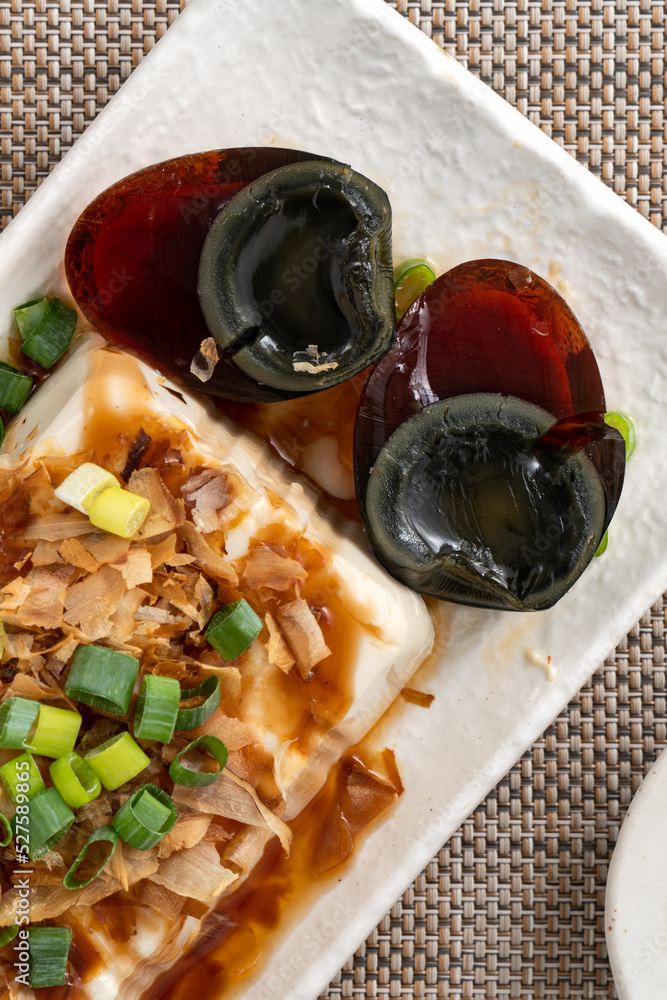 美味的冷冻豆腐和世纪鸡蛋配酱油和鲣鱼片。