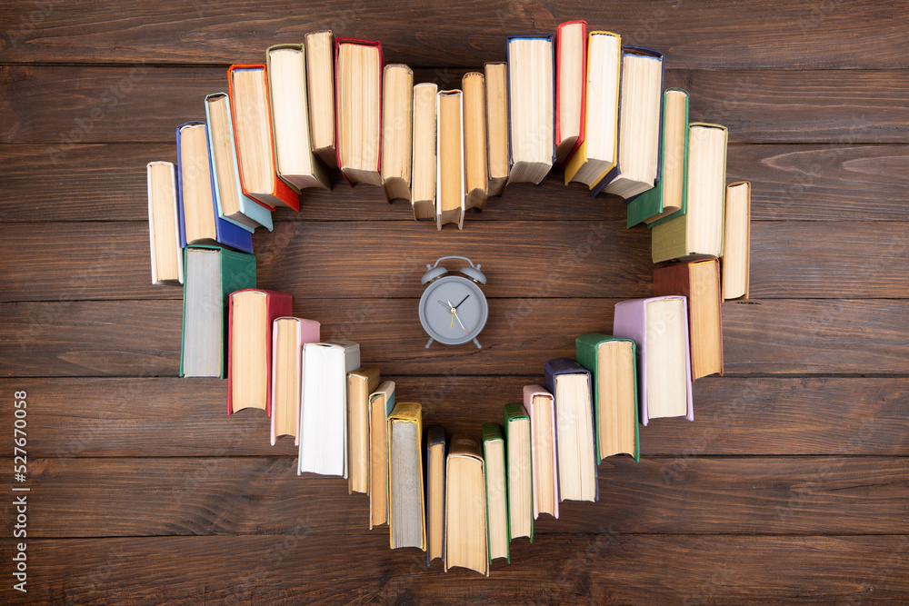 热爱科学概念。木制桌子上书籍和时钟的心形。是时候攻读自然学位了