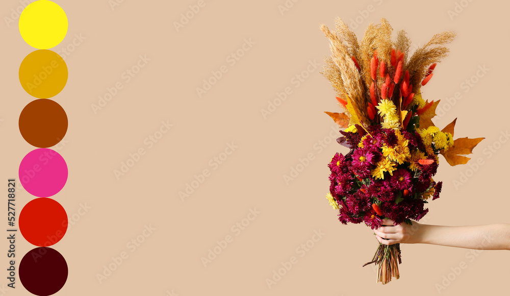 Female hand with beautiful autumn bouquet on beige background. Different color patterns