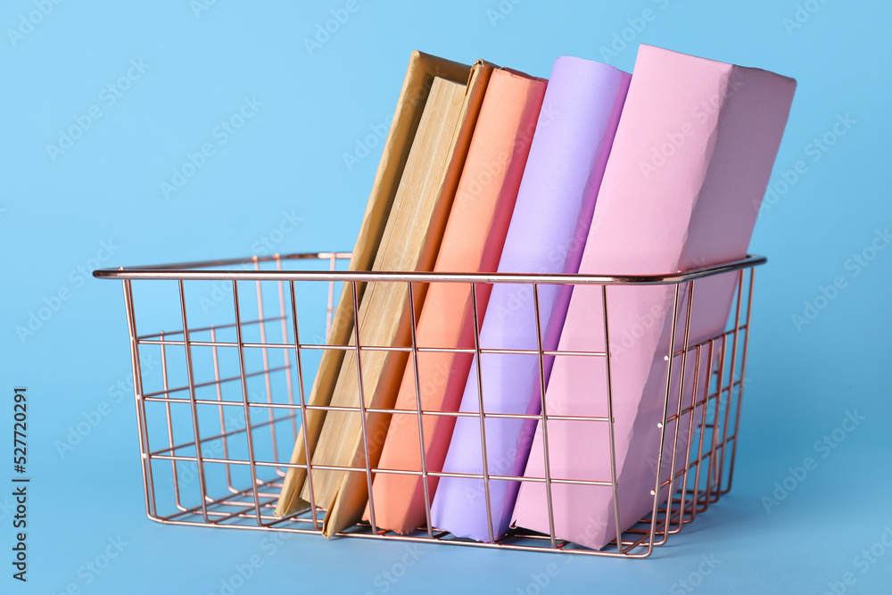 粉红色金属篮子，蓝色背景有书