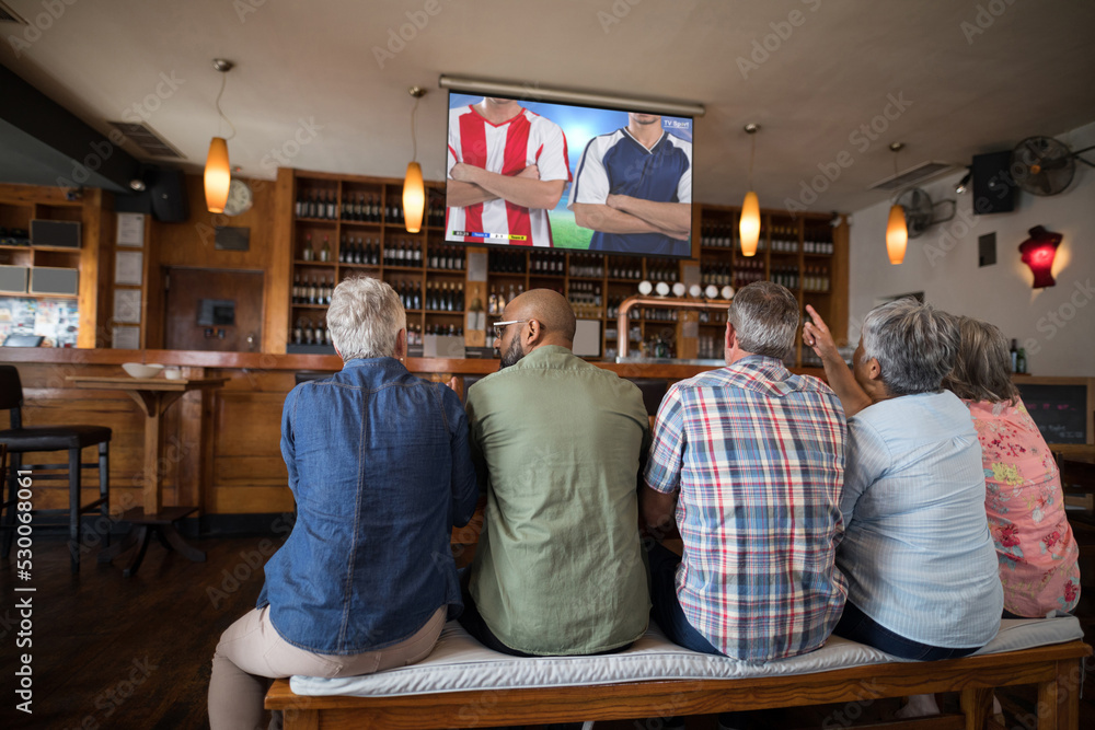 酒吧里形形色色的老朋友在看电视，屏幕上有足球比赛