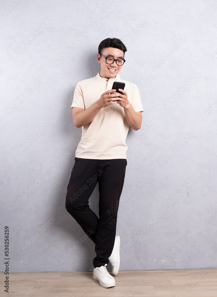亚洲年轻男子使用smarphone的完整图像