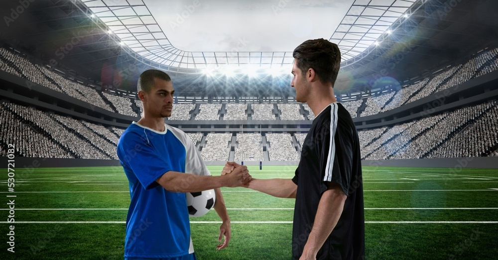 Composition of two male football players shaking hands over sports stadium