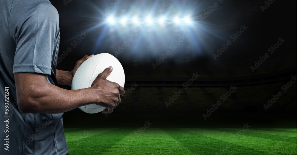 男子橄榄球运动员在体育场上空拿橄榄球的构成