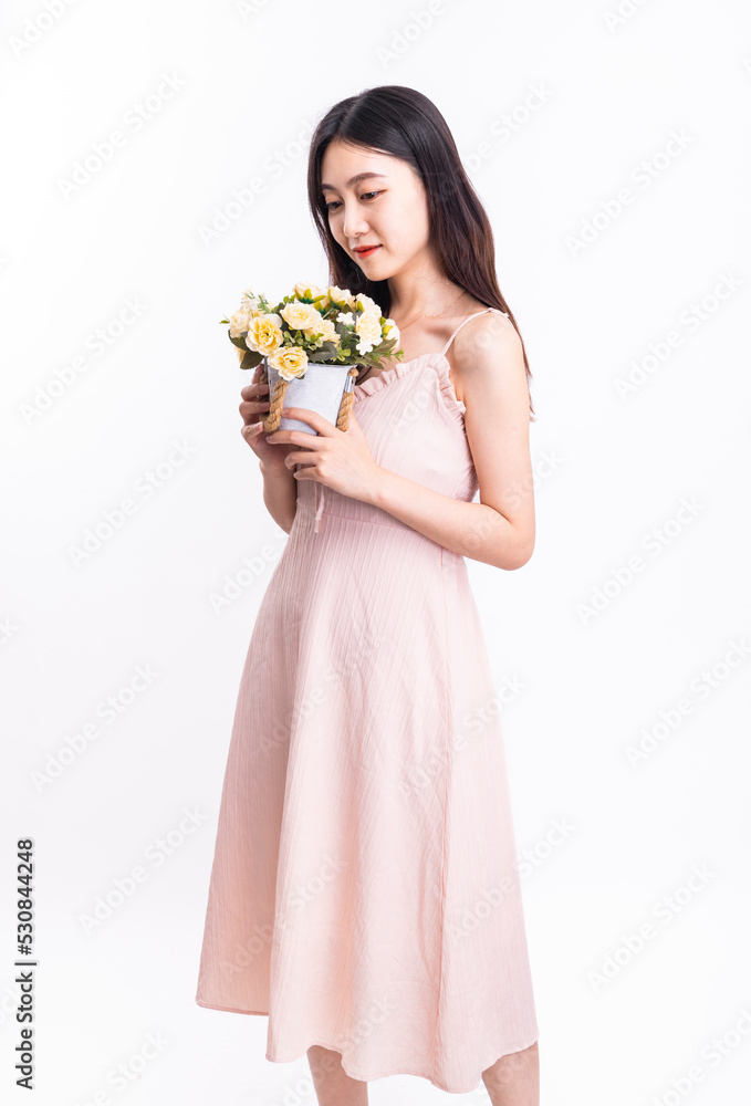 一个穿着粉色连衣裙，手里拿着一壶花的女人