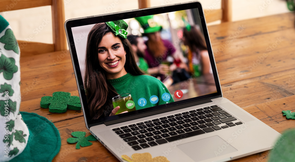 微笑的白人女性在酒吧用笔记本电脑屏幕进行圣帕特里克节视频通话