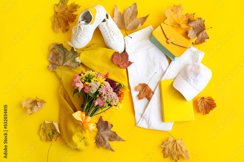 黄色背景下的女性服装、花束和秋叶