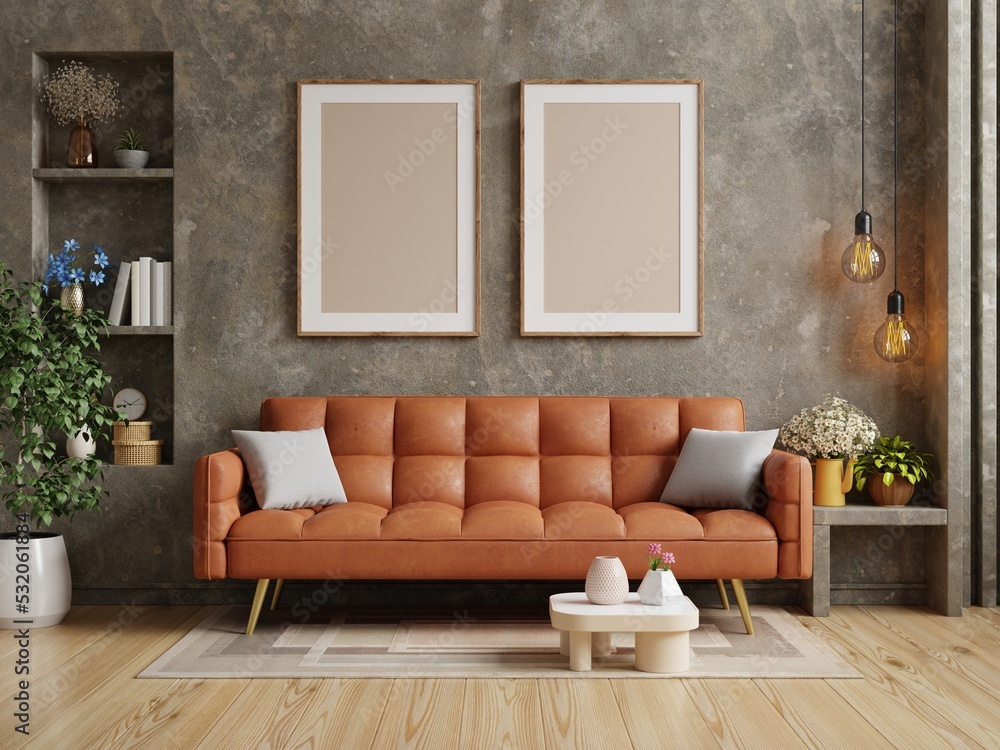 客厅有橙色的皮沙发和混凝土墙上的海报框架模型。