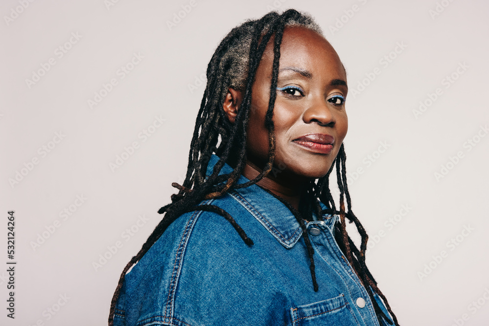 Stylish woman with dreadlocks looking at the camera in a studio