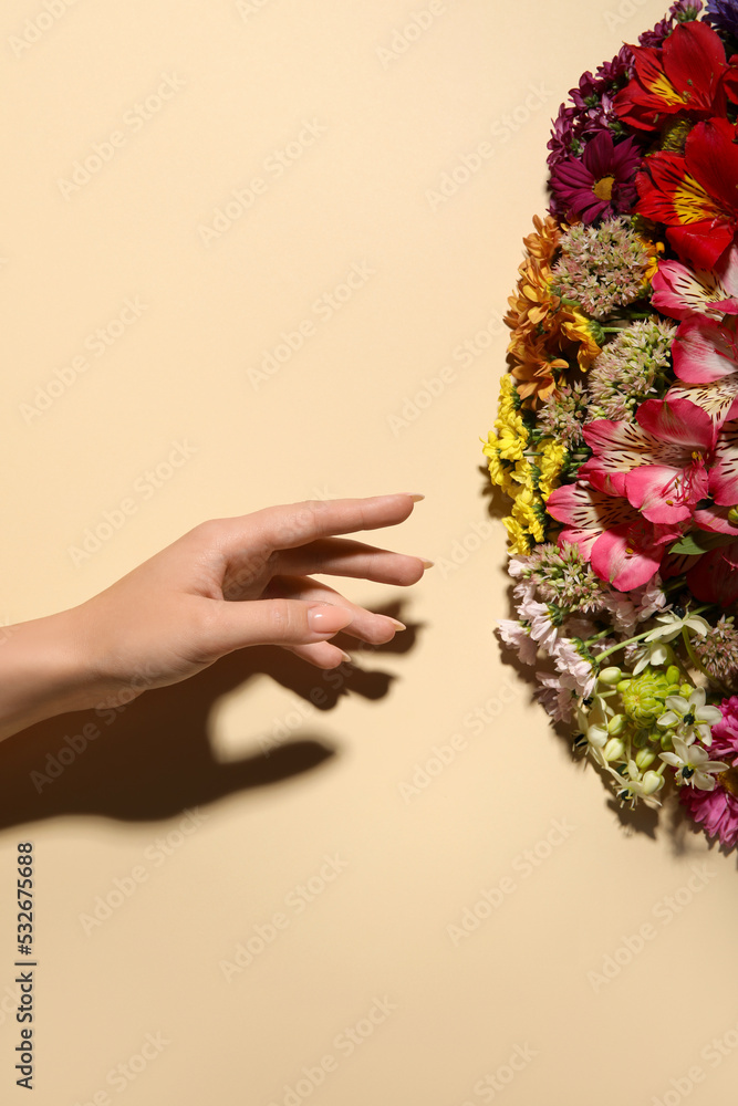 米色背景下的女性手和一束美丽的花