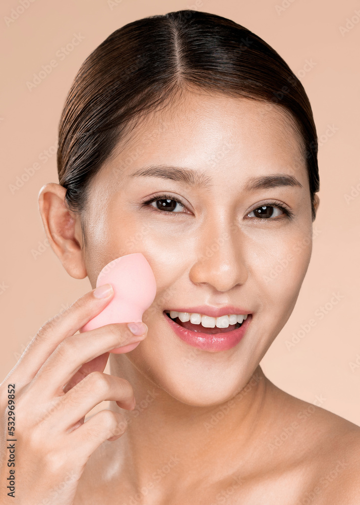Closeup ardent woman applying her cheek with dry powder and looking at camera. Portrait of younger w