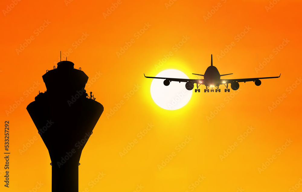 日落时有飞机靠近的机场交通管制塔