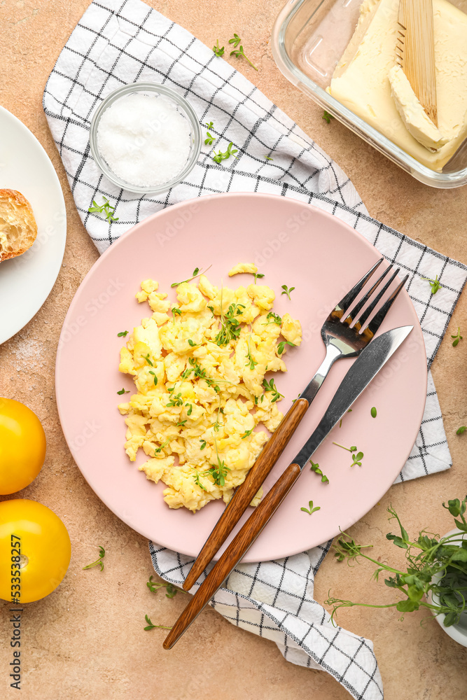 Plate of delicious scrambled eggs on color background