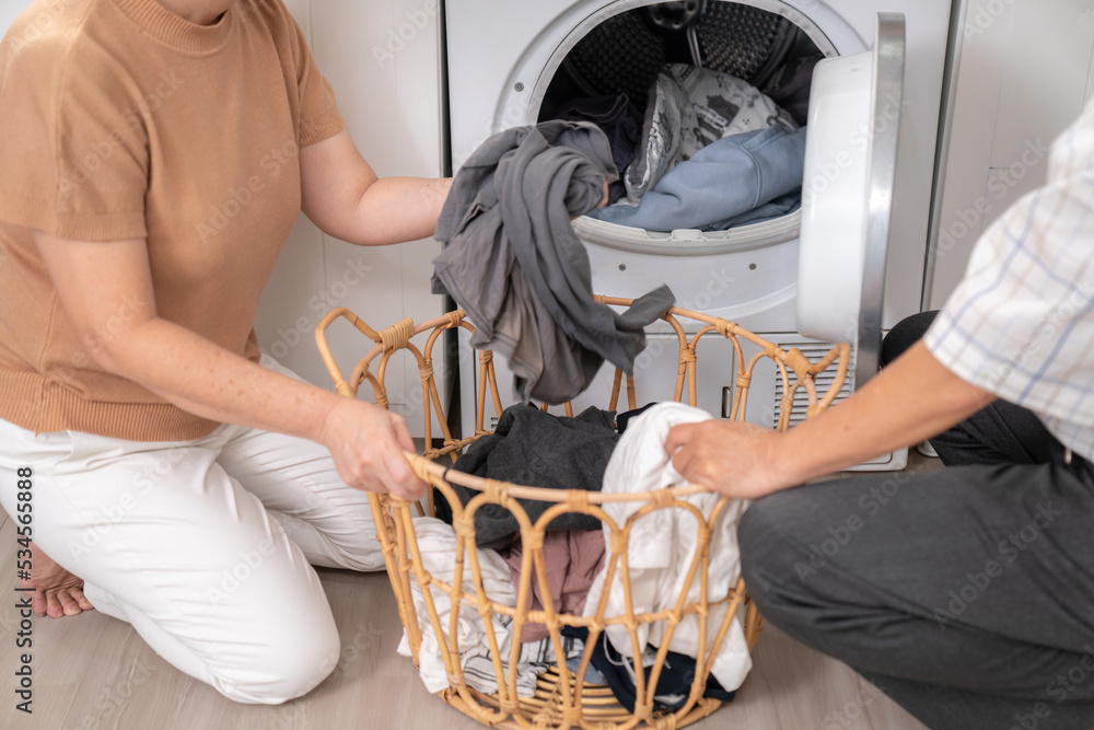 一对老年夫妇一起在洗衣机前快乐地完成家务