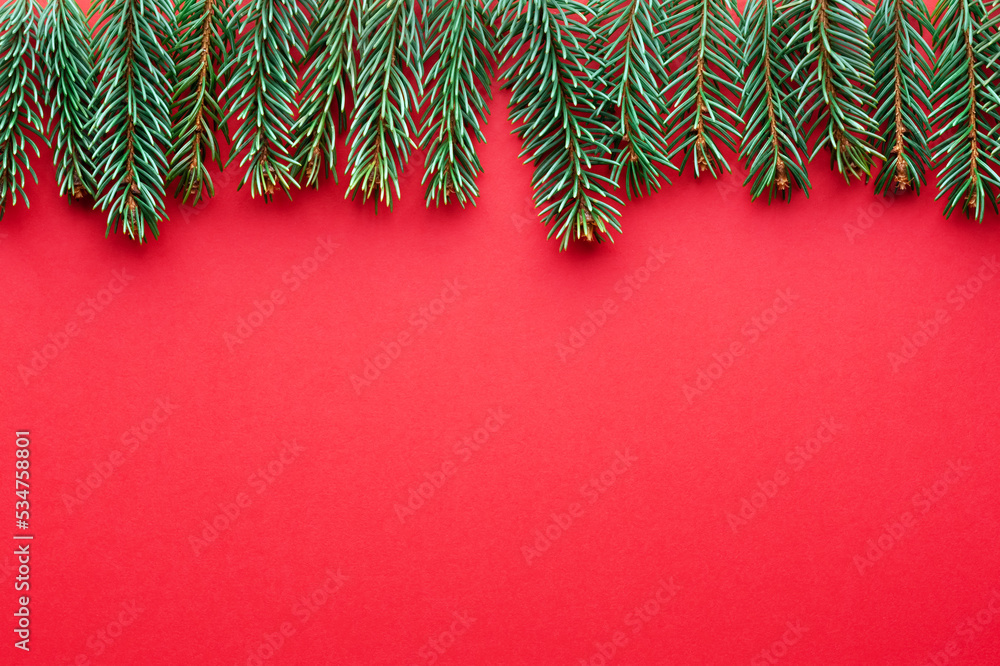 富有创意的圣诞假期背景，红色硬纸板背景上有冷杉枝。平躺，t